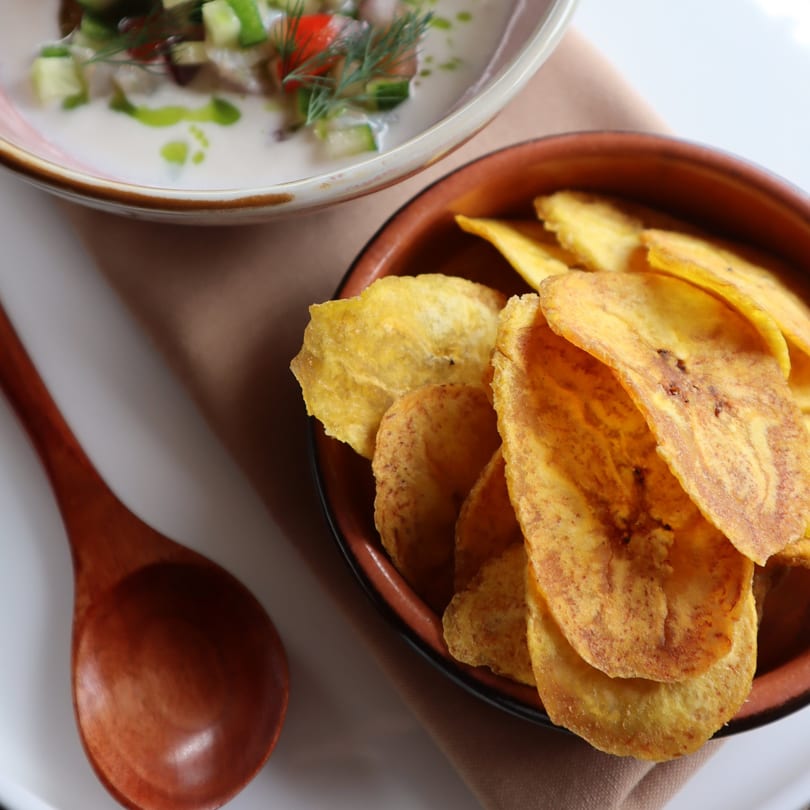 Comida's ceviche with green herbs and red peppers, served with a side of plantain chips.